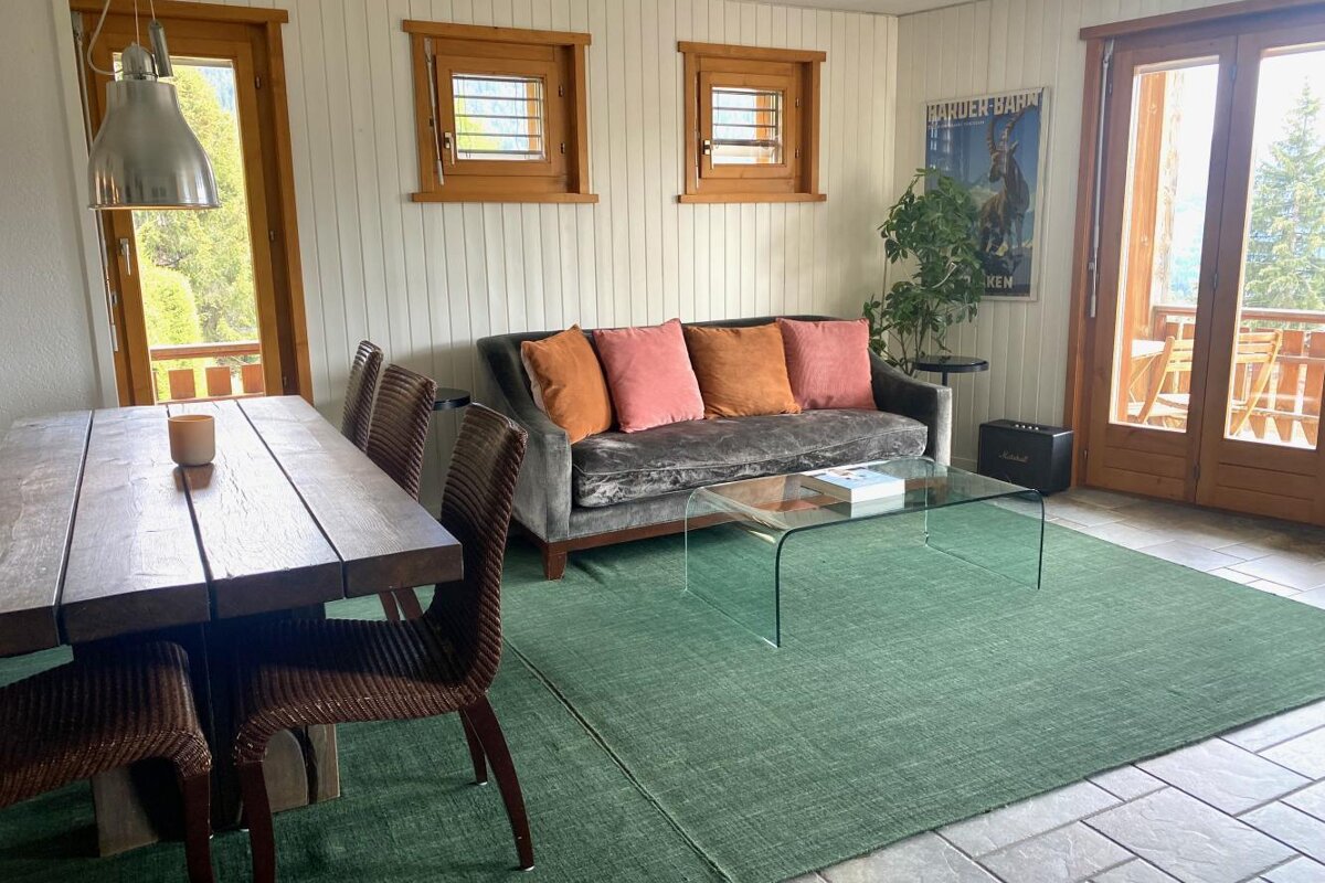 A living room with a couch a table and chairs and a poster on the wall that says