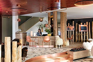 A woman sits at a counter in a hotel lobby
