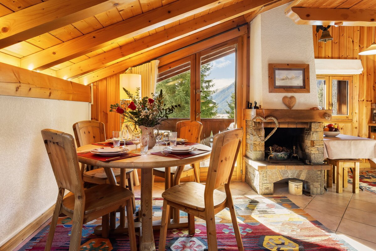 A dining room with a table and chairs and a fireplace