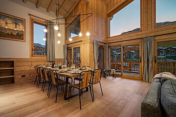 A wooden dining room with a table and chairs
