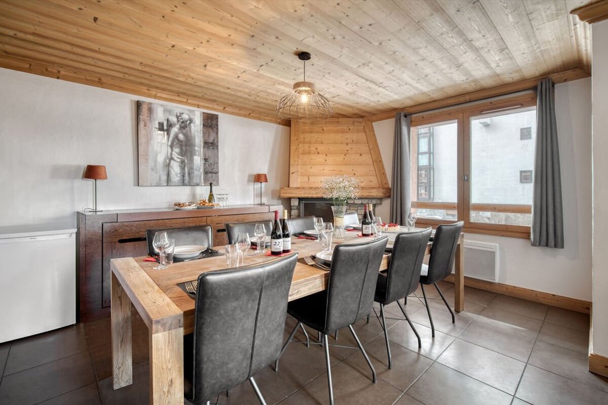 A dining room with a wooden table and chairs