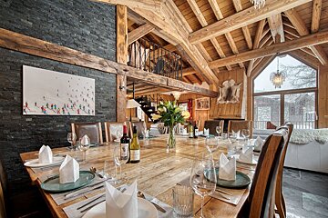 A dining room table with a bottle of wine on it