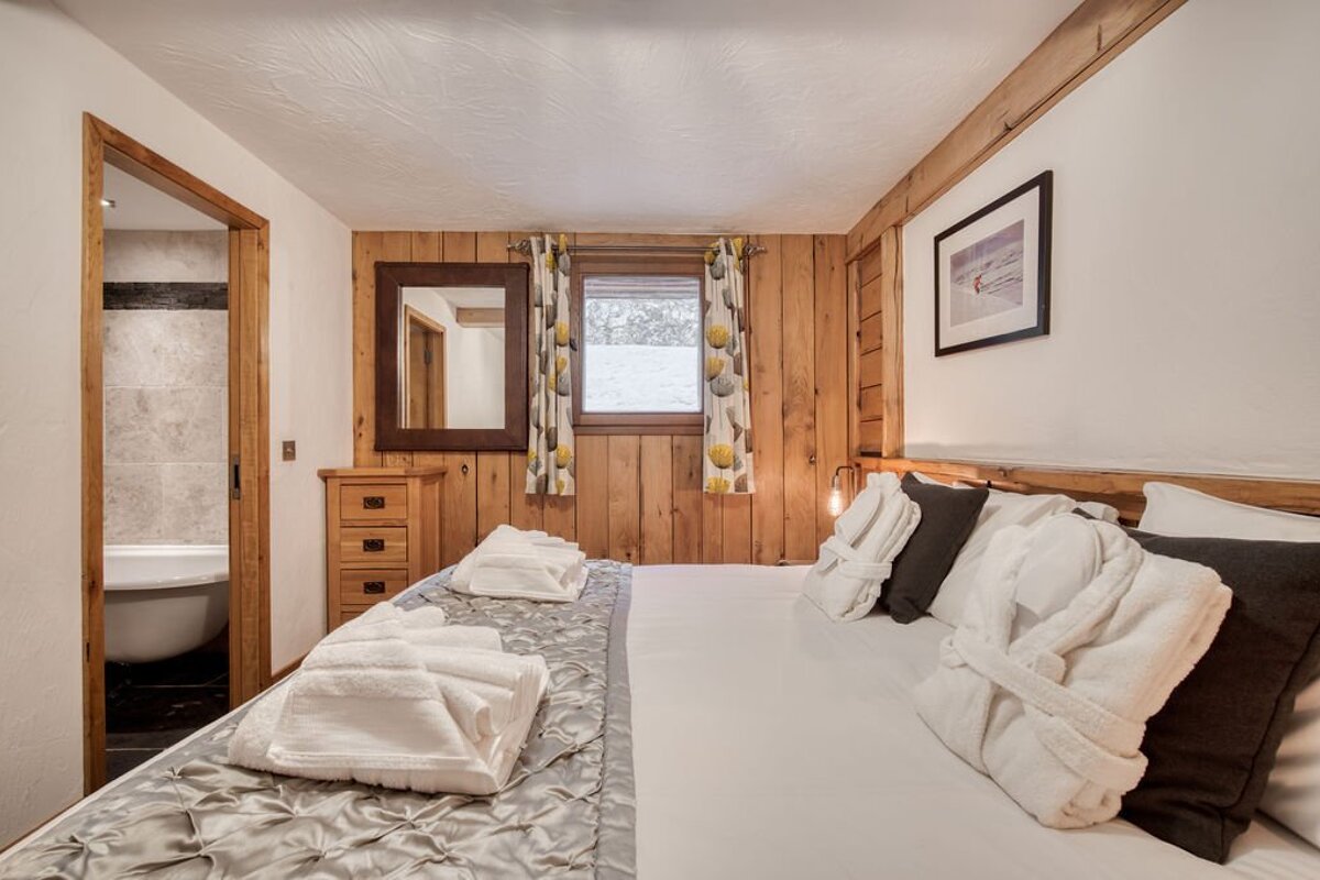 A bedroom with a large bed and a picture on the wall