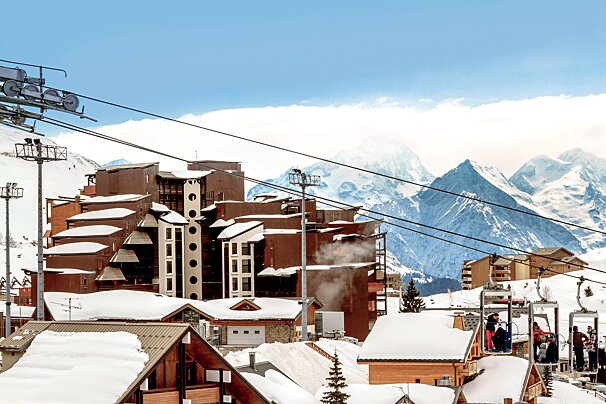 A ski lift is going up a snowy mountain
