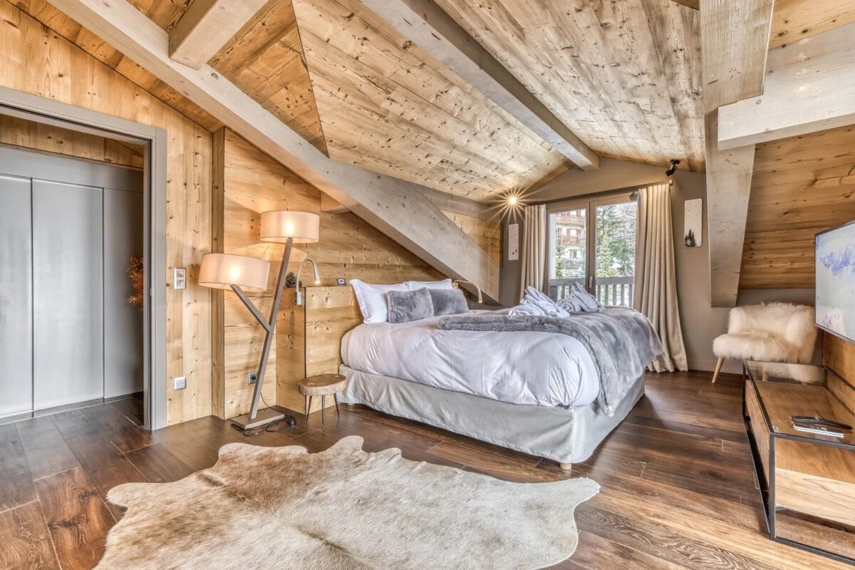 A bedroom with a large bed and a rug on the floor