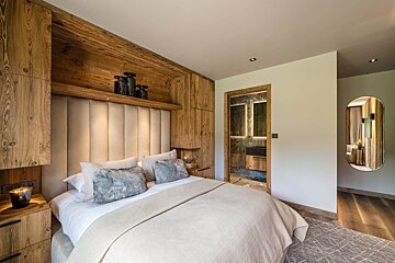 A bedroom with a large bed and a mirror