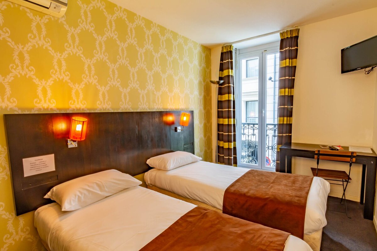 A hotel room with two beds and a desk