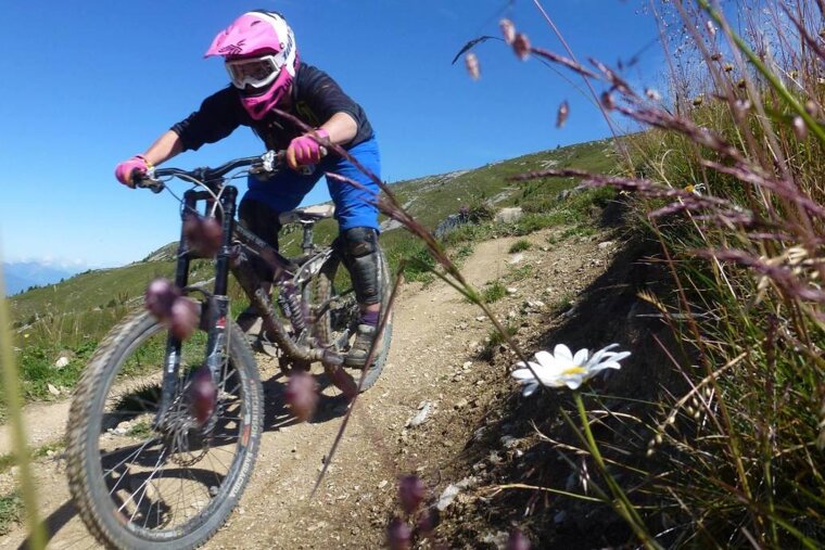 a girl mountain buiking on a trail int eh alps