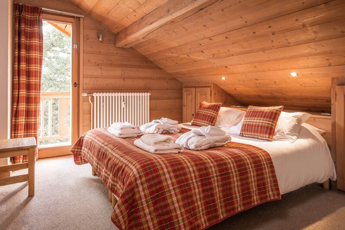 A bedroom with a king size bed and a chair