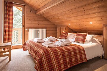 A bedroom with a king size bed and a chair