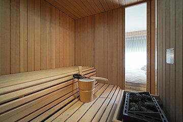 A wooden sauna with a ladle and bucket on the bench
