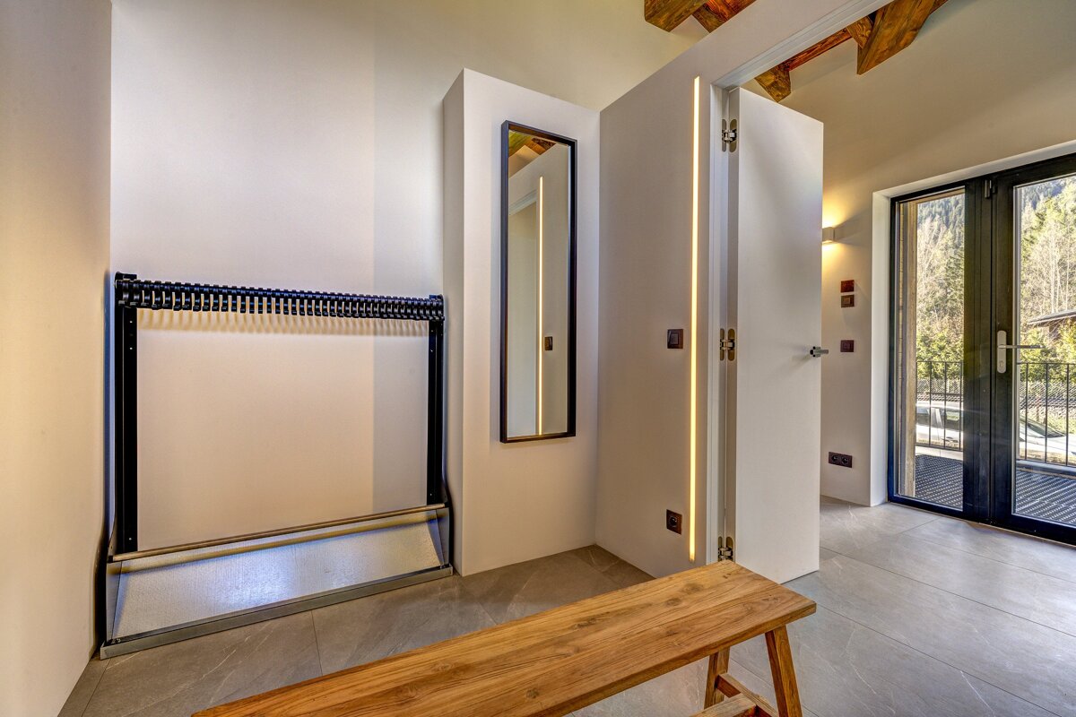 A room with a bench and a mirror on the wall