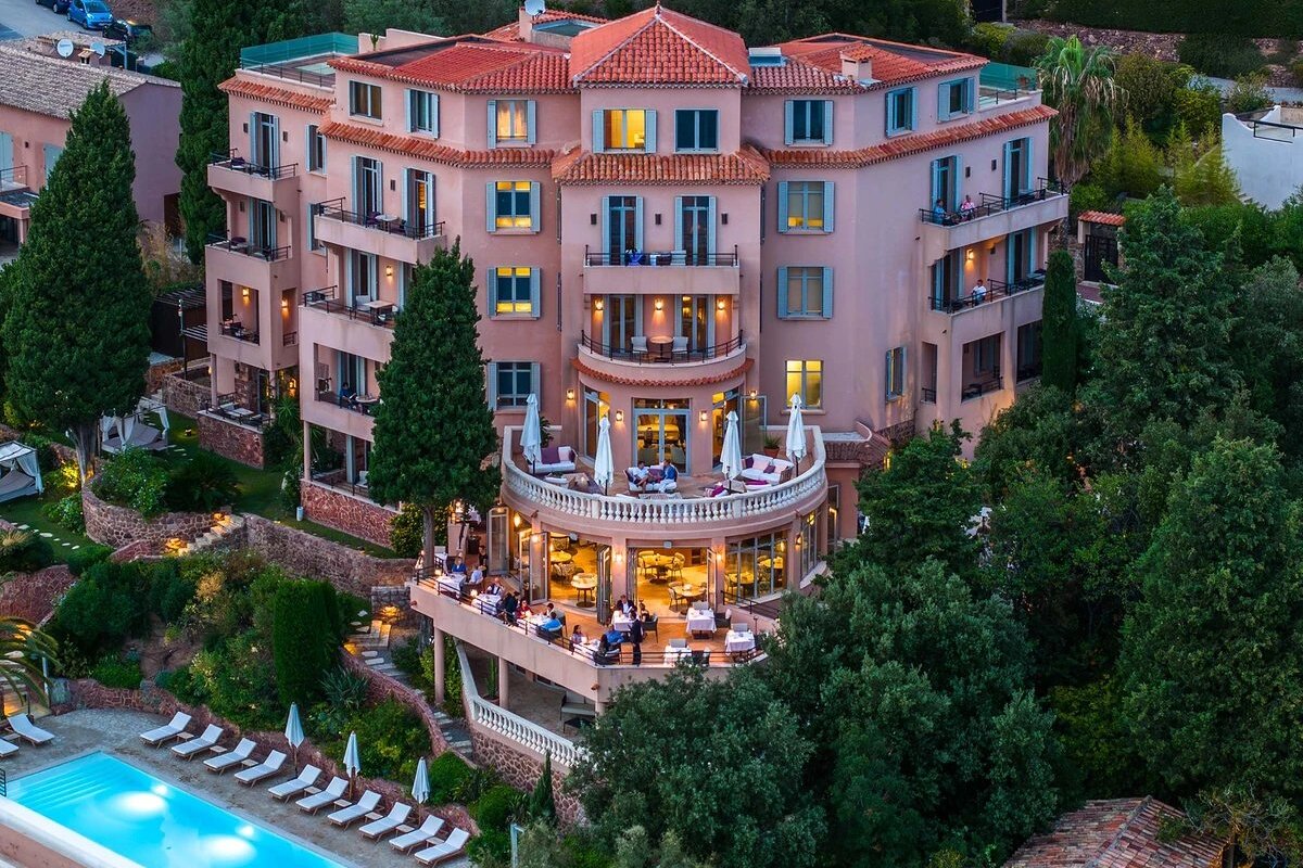 A large pink building with a swimming pool in front of it