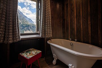 A bathtub in a bathroom with a view of mountains