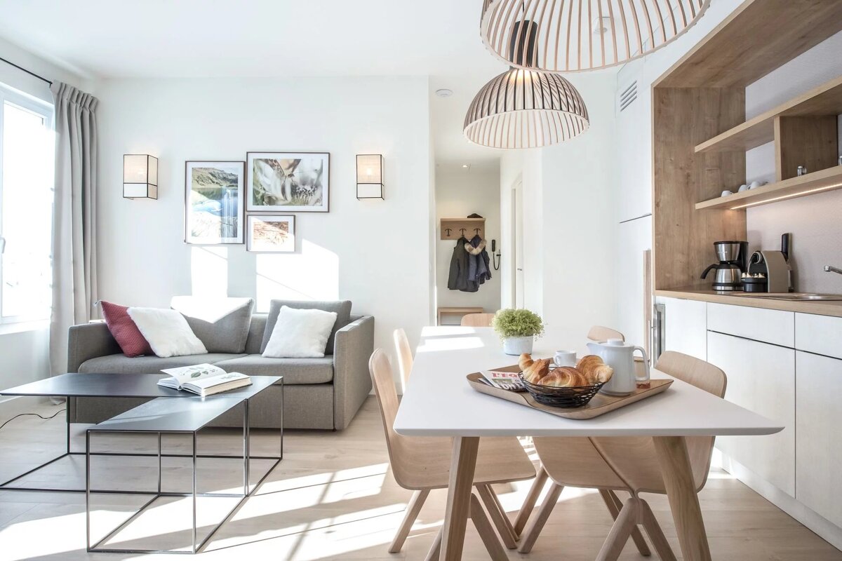 A living room with a couch and a table with a tray of croissants on it