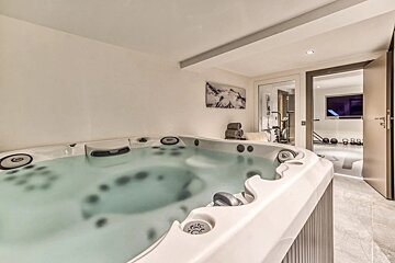 A hot tub in a room with a painting on the wall above it