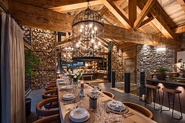 A dining room with a long wooden table and chairs