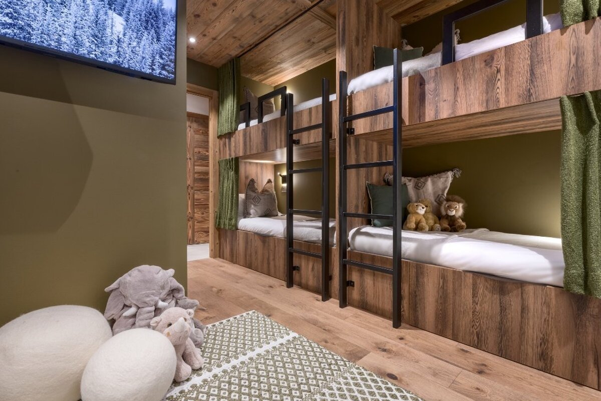 A bunk bed with a ladder and stuffed animals on it