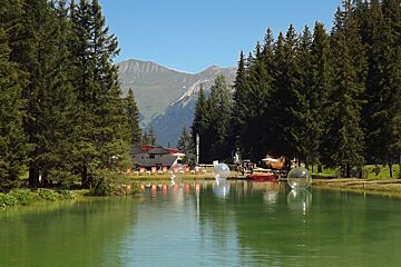 A lake surrounded by trees with a mountain in the background