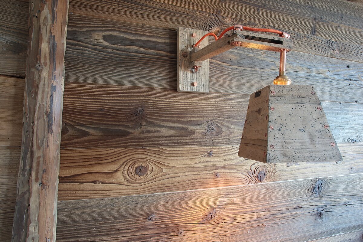 A wooden wall with a light hanging from it