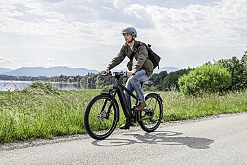 A man wearing a helmet is riding an electric bike