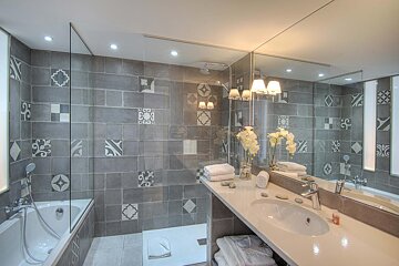 A bathroom with a sink and a walk in shower