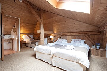 A bedroom with two beds and a skylight