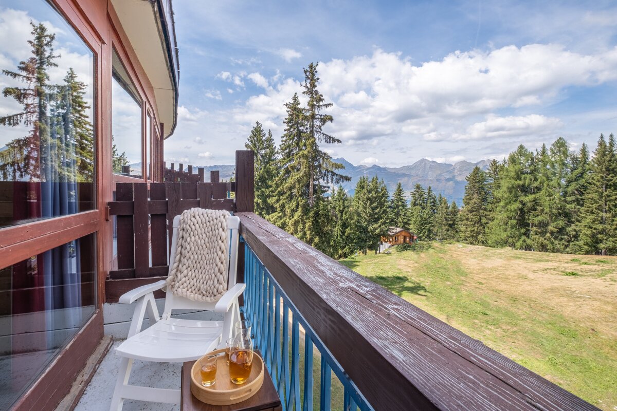 A balcony with a rocking chair and a tray of tea