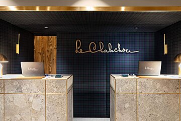 Two desks in front of a sign that says le chalechou