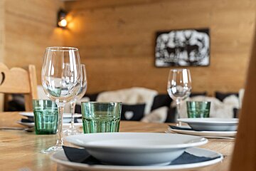 A table set with plates bowls and wine glasses