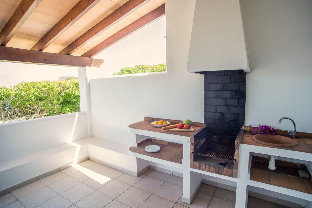 A small kitchen with a bbq and a sink