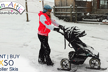 A woman pushes a stroller with skis attached to it