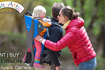A man and woman carrying a child in a fan-attic backpack carrier