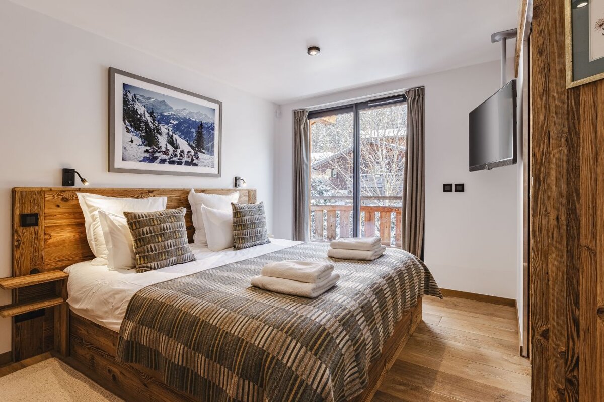 A bedroom with a large bed and a television