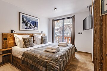 A bedroom with a large bed and a television