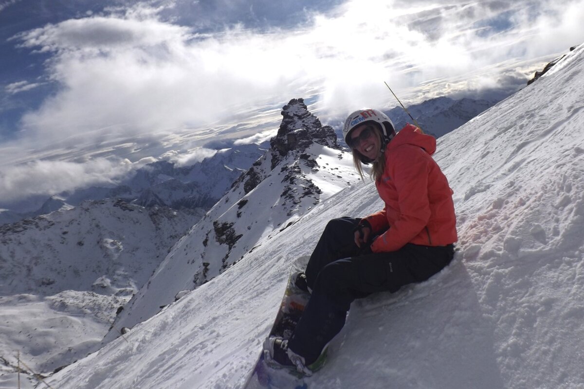 a woman in a red jacket on a steep piste in Orelle