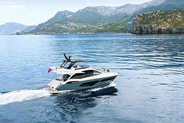 A boat is floating in the ocean with mountains in the background