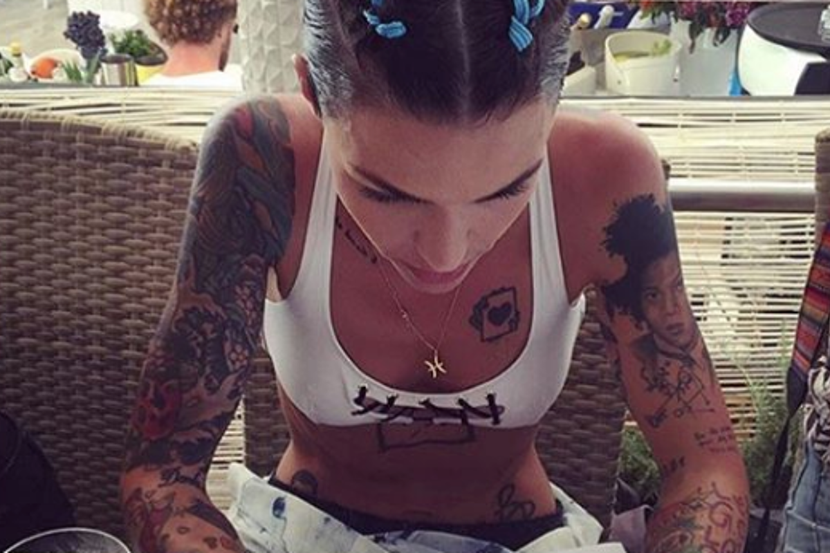 A woman with a lot of tattoos is sitting in a chair