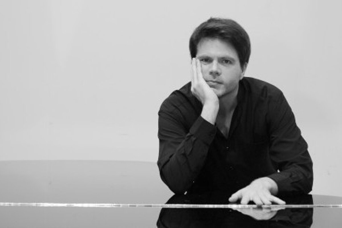 a man leaning his hand on his chin on a piano