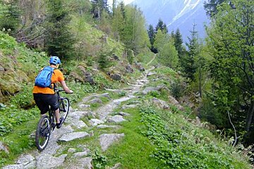 A person riding a bike down a rocky trail