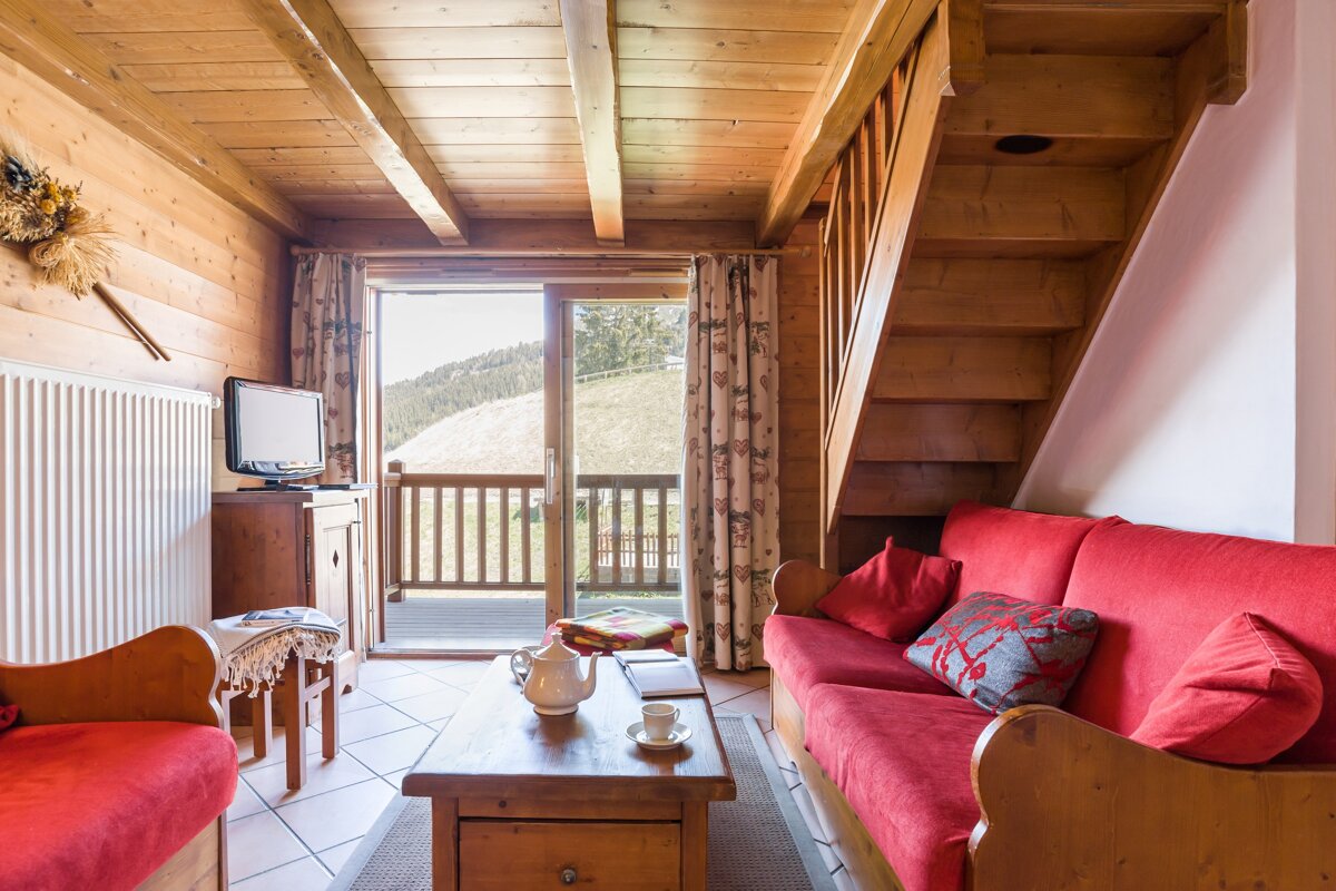 A living room with a red couch and stairs