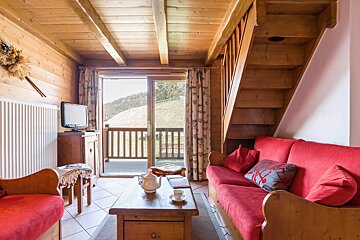 A living room with a red couch and stairs
