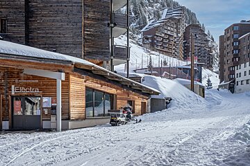 A snowmobile is parked in front of a building that says electra