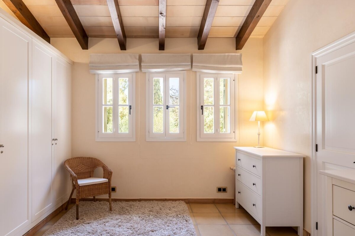 An empty room with a chair and a dresser