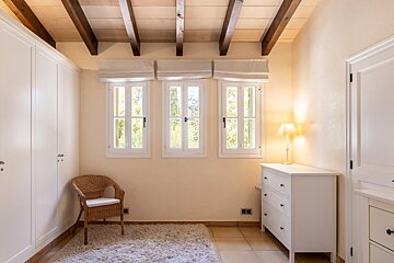 An empty room with a chair and a dresser