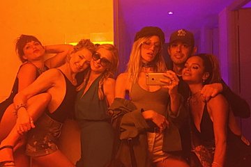 A man wearing a ny yankees hat takes a selfie with his friends