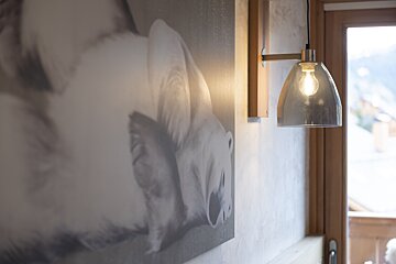 A picture of a polar bear hangs on a wall next to a light