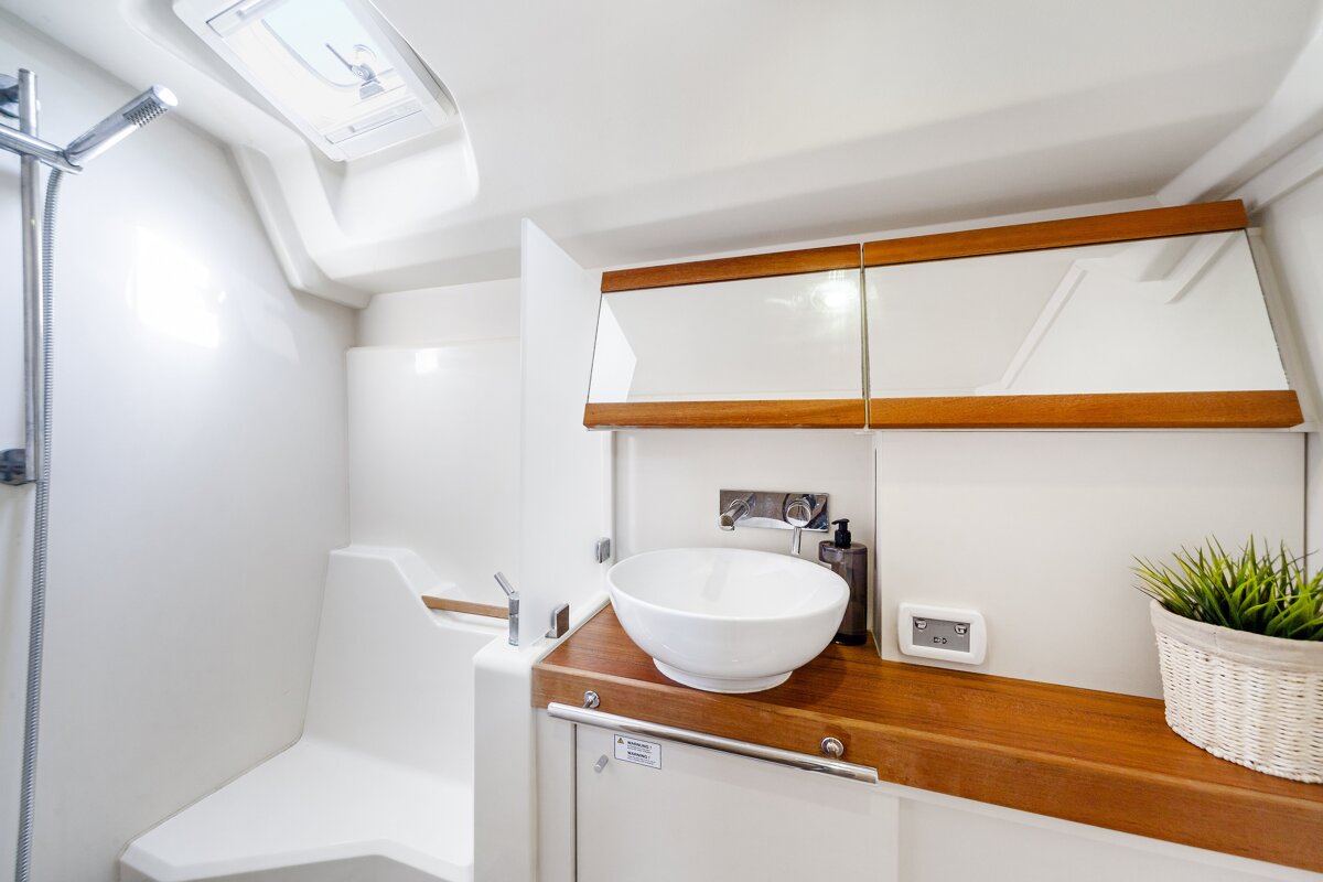 A bathroom with a sink a mirror and a thermostat