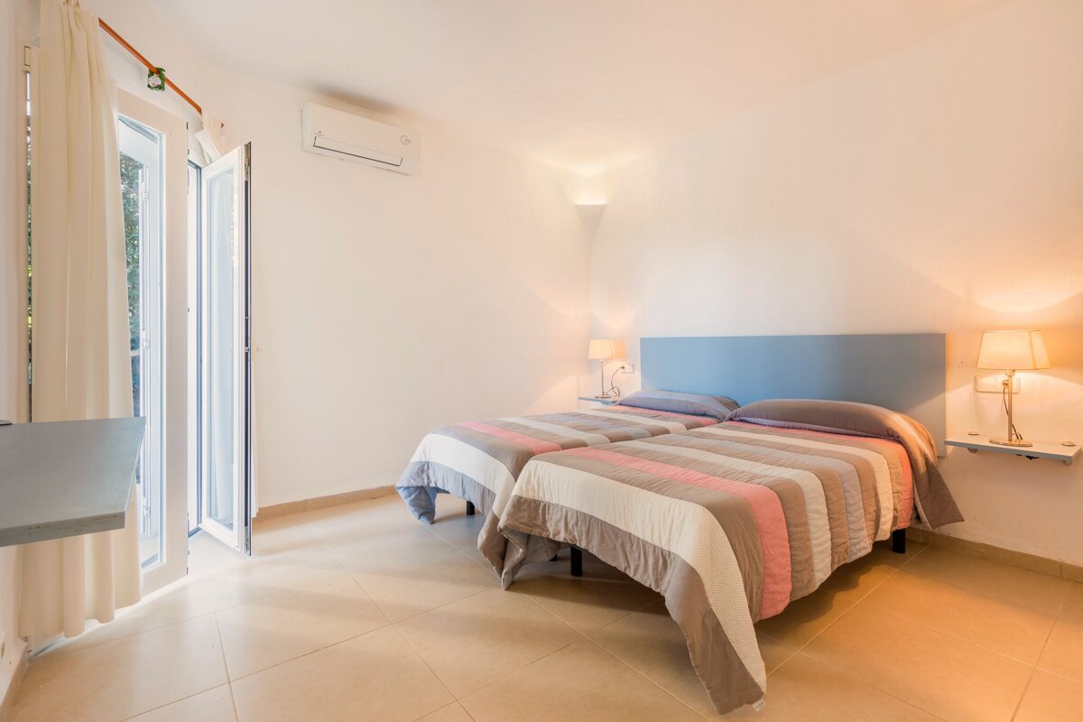 A bedroom with two beds and a blue headboard