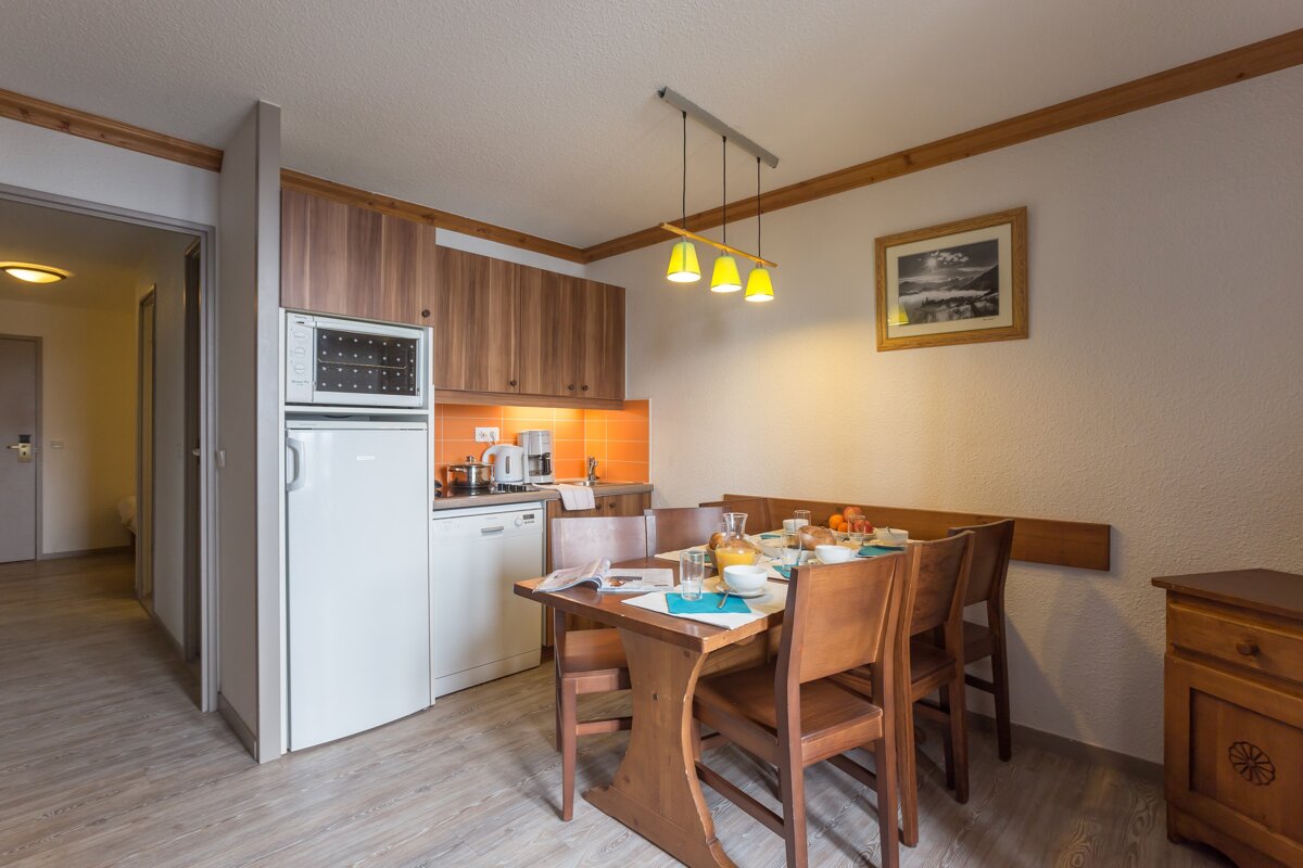 A kitchen with a table and chairs and a refrigerator that says ' lg ' on it